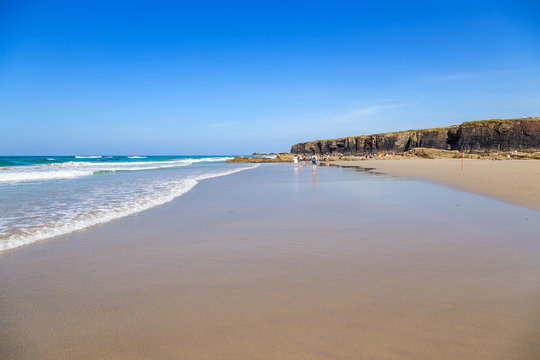 Ribadeo, Spain. Tourists on the picturesque Holy Water Beach (Praia de Augas Santas)