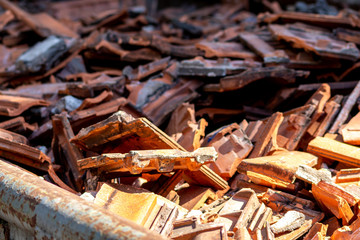 Schuttcontainer gefüllt mit kaputten Dachziegeln nach einem Sturm zeigt das Ausmaß der Sturmschäden an den Dächern der Häuser und der Notwendigkeit zur Sanierung und Restaurierung beschädigter Häuser