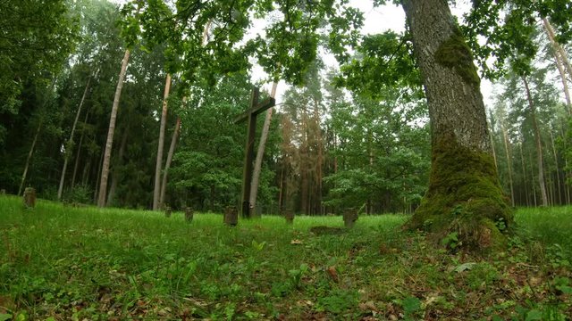 A large wooden cross in the cemetery of WWI German soldiers and victims. Pan Left