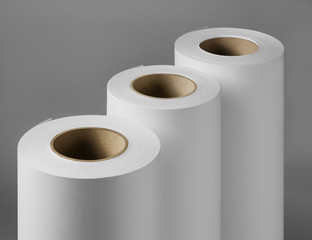 Blank white paper rolls isolated on gray background. Mockup paper for magazines, catalogs or newspapers isolated on gray backdrop, Printing house theme or wrapping paper for presents