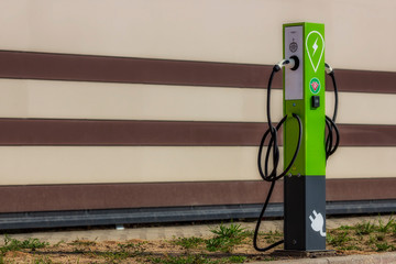 Electric car charging stations on the background of a striped wall. Column for charging electric cars. 