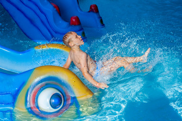 Child On Water Slide At Aquapark.
