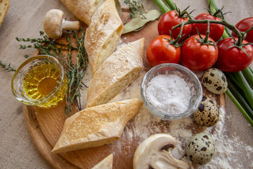 bread composition with herbs and vegetables on a baker's table