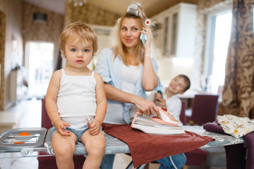 Housewife talking by phone, kids fooling around