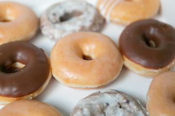 Top view of box of a dozen mixed donuts, close up, white background