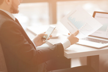 closeup.businessman counting profit using a smartphone. business concept