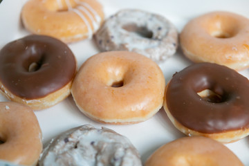 Top view of box of a dozen mixed donuts, close up, white background