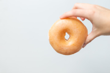 Girl holding plaid glazed donut, white background, copy space