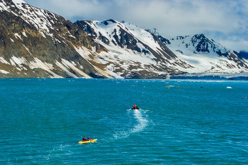 A raft and toutists in inflatable kayaks in the Arctic Ocean, Hornsund, Norway