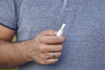 Electronic cigarettes, cigarette technology. Tobacco IQOS system. Close-up of a man smoking an...