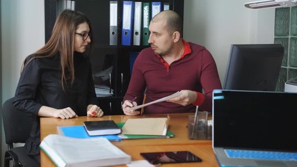 The investigator at the police station questioning the witness about the special signs of the criminal. Identikit drawing.
