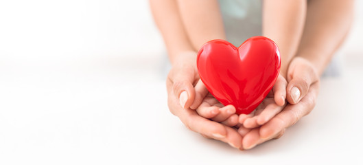 The adult and the child holding red heart.