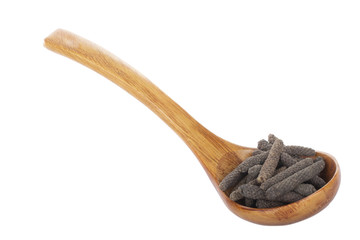 heap of pippali (long pepper) in wooden spoon isolated on white background