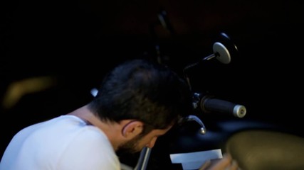  man repairing his motorcycle in the garage.
