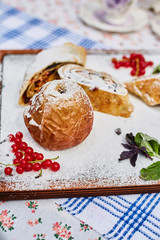 Sugar baked apple on a board sprinkled with powdered sugar