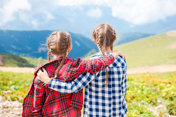 Beautiful happy little girls in mountains in the background of fog