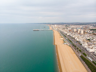 Aerial photo of the famous Brighton Pier and ocean located in the south coast of England UK that is part of the City of Brighton and Hove, taken on a bright sunny day showing the fairground rides.