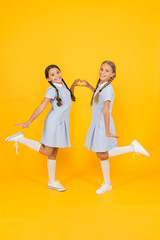 sisterhood love. children in vintage style. old school. happy friends on yellow background. kid fashion. childhood happiness. small girl in school uniform with retro look. friendship and love concept