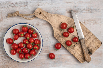 ripe cherry tomatoes and knife on a wooden table