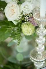 Wedding table setting is decorated with fresh flowers and white candles. Wedding floristry. Bouquet with roses, hydrangea and eustoma. Table numbering