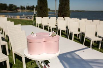 Beautiful outgoing wedding set up. Jewish Hupa  on romantic wedding ceremony , wedding outdoor on the lawn. Wedding decor. A pink box for presents in the shape of a heart is on the table