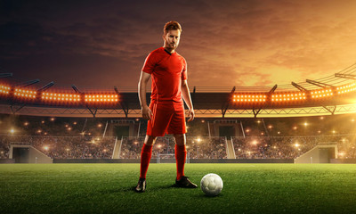 Soccer player in sport uniform ready for the game. Stadium with green grass, tribunes and dramatic...