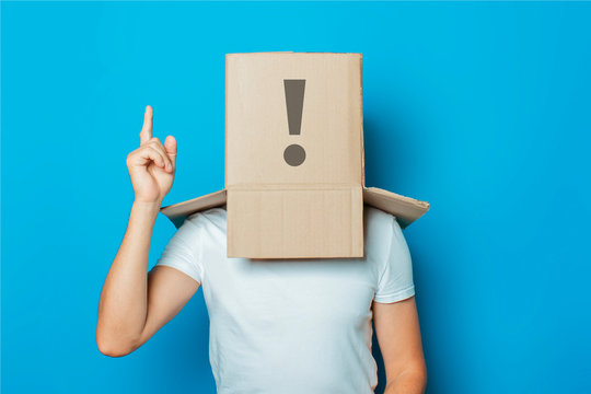 Young man in a white T-shirt with a cardboard box on his head ma