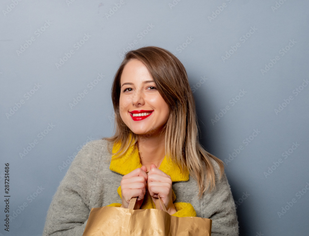 Wall mural style woman in coat with shopping bag