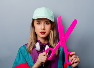 woman in 90s clothes style with big scissors