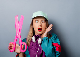woman in 90s clothes style with big scissors