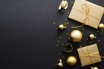 Elegant Christmas background with modern golden Christmas decorations, baubles, gift boxes, confetti stars on dark black backdrop. Flat lay design, top view, copy space. - Powered by Adobe
