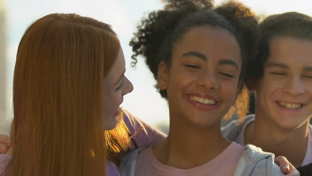 Cheerful female friends and male hugging and laughing on camera, sincerity