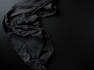 crumpled black gauze fabric on a black background