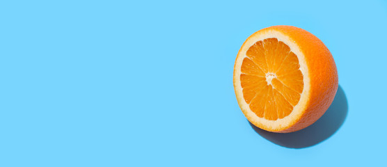 Ripe juicy delicious orange on blue background. Healthy eating and dieting concept