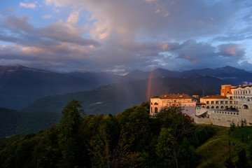 Resort at sunset in the mountains with a rainbow.