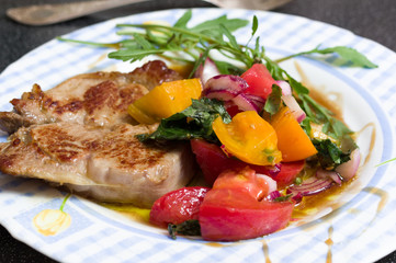 Sliced fried steak and vegetable salad. Greens and salad.