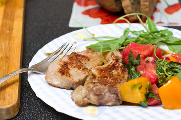 Macro photo of a pork steak. Pork steak with salad.