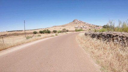 secondary paved road on a summer landscape approaching Magacela, province of Badajoz, Extremadura, Spain
