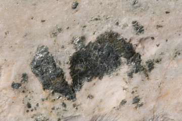 Stone texture and background. Rough natural rock with silver colored minerals in the stone.