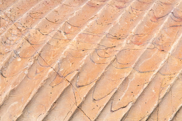 Antique light red marble indented texture and background.  Rough natural rock texture with rills.