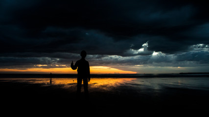 Obraz premium silhouette of a man on the beach at sunset