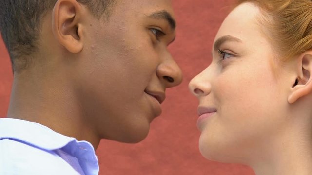 Sun-kissed female teen ready to kiss mixed-race boyfriend, romantic date, love