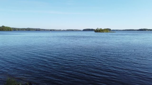 Tranquil lake view on summer day in Finland. Only small ripple on water surface.