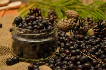 Black mountain ash, pine cones and branches on the background of burlap. Preparations for the winter. Gift of nature.