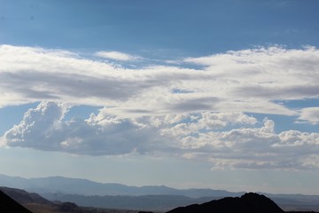 Assemblages of vapor waft above Southern Mojave Desert land surrounding the West Entrance to the environment of Joshua Tree National Park, with the town of Joshua Tree visible several miles behind.
