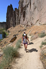 Obraz premium Young couple ascend Misery Ridge Trail in Smith Rock State Park, Oregon on a cloudless summer day.
