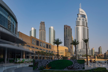 Panorama of tall Skyscrapers in skyline of Dubai against blue sky.