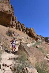 Young woman on Misery Ridge Trail in Smith Rock State Park near Terrebonne, Oregon on a coudless summer day.