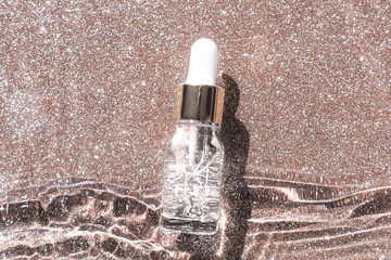 Anti aging serum with collagen and peptides in glass bottle with dropper on golden background. Skincare essence for beautiful healthy skin. 