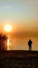 Fototapeta premium silhouette of man on the beach at sunset